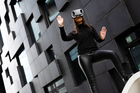 敬业的女人戴着虚拟现实技术眼镜和黑色衣服图片