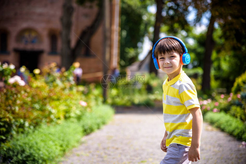 立体声儿童男孩秋季装享受音乐小孩听音乐享受最喜欢的歌曲出色的声音只有良好的氛围很棒的声音带耳机城市背图片