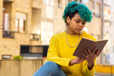 年轻的美国黑人女孩在户外看书图片