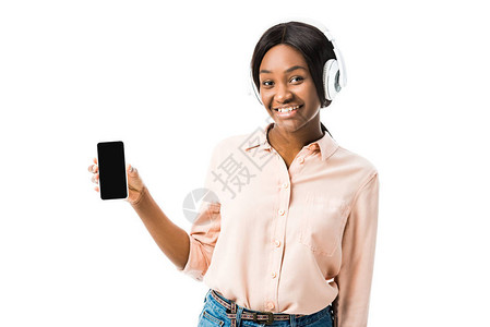 身穿衬衫头戴耳机手持智能手机的非洲裔美国女面带微笑图片