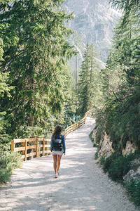 带着背包的快乐女人在公园山上走着小路图片