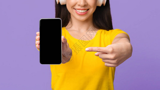 素材在线识别下载音乐在线下载耳机中无法识别的女童用黑色空白屏幕指向智能手机用于Mockup裁剪图像C背景