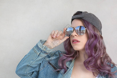 穿紫色头发的光荣女人戴帽子太阳眼图片