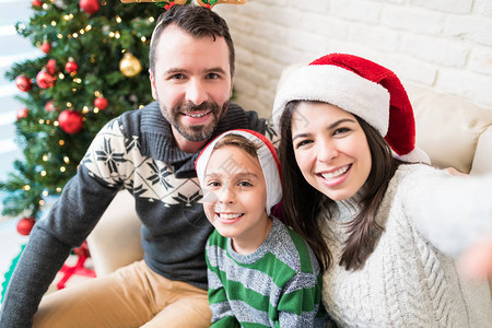 在家庆祝圣诞节时微笑的家庭在家中制图片