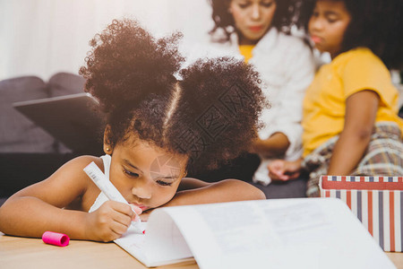美国黑人学龄前女儿孩子与姐一起在家做庭作业学习教育图片