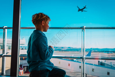 男孩在机场等待看着飞机图片