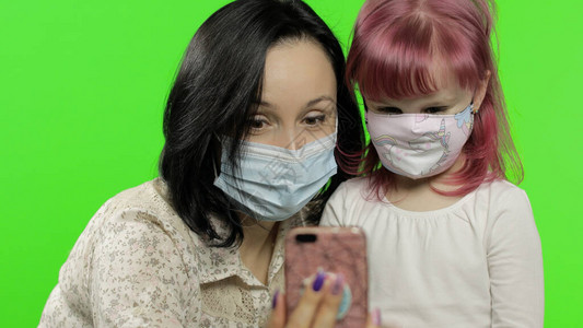 女儿戴着面具拿着电话在视频通话中交谈图片