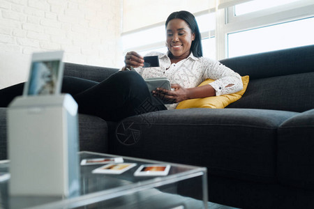 在家用便携式无线迷你打印机打印图片的黑人妇女图片