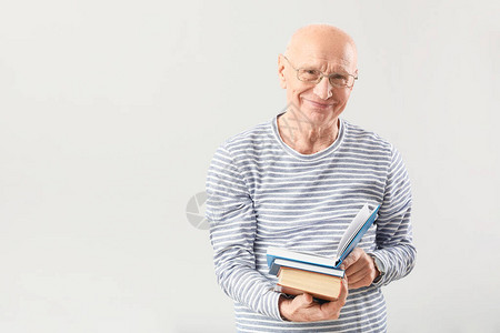 灰色背景书籍的老人肖像图片
