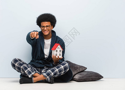 年轻黑人男子拿着房子模特图片