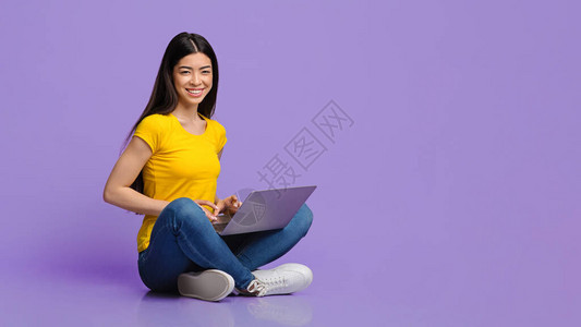 千年亚洲女孩坐在台下手持笔记本电脑的千百年时间里图片