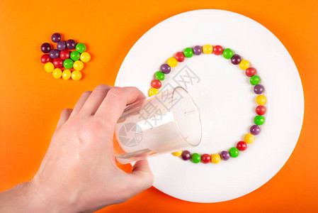 由水果味彩色糖果制成的彩虹漩涡有趣的儿童科学实验一步的照片说图片