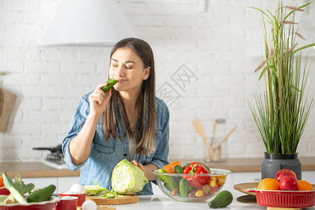 一位年轻漂亮的女人正在厨房里准备各种蔬菜沙拉健康饮食和生图片