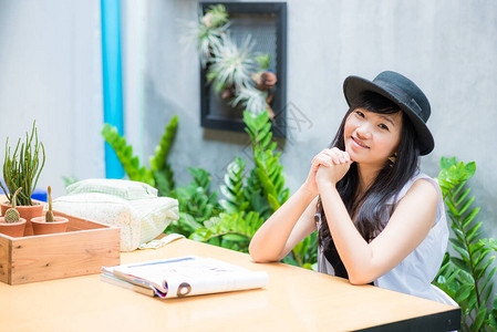 坐在咖啡馆的亚洲学生妇女用图片