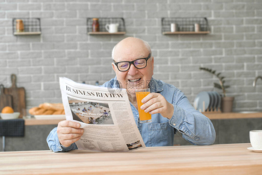 家中阅读报纸时老人喝果图片