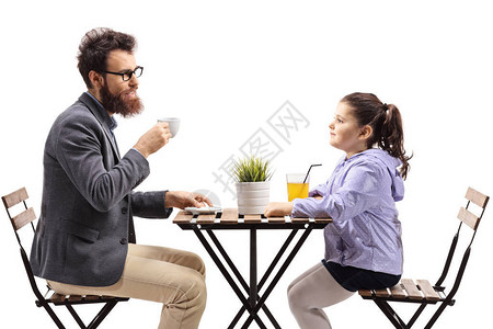 在餐厅喝咖啡和橙汁的男人和小孩白种树下图片