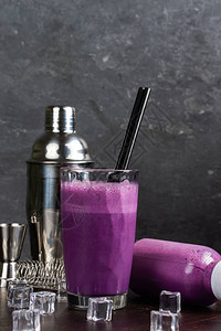 杯子和一瓶紫色饮料鸡尾酒瓶加冰块在桌图片