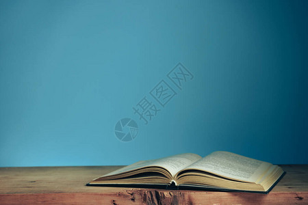 新书推介红色木桌和蓝色墙壁背景上的漂亮打开书背景