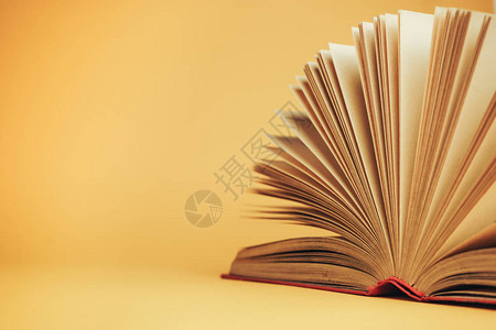 新书上架黄色背景上的漂亮打开的红色书背景