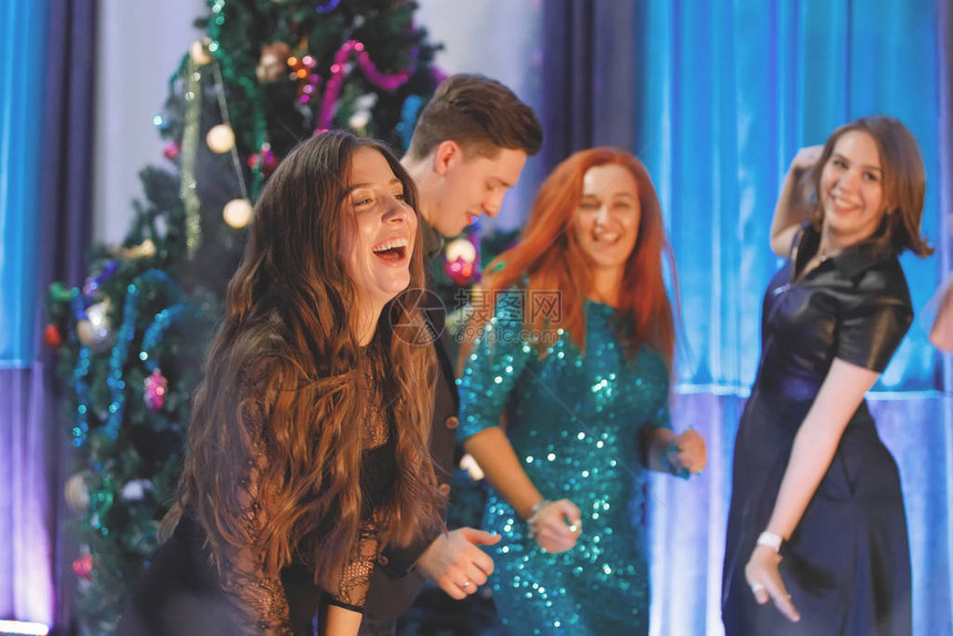 一群快乐的朋友在圣诞树附近跳舞女人图片