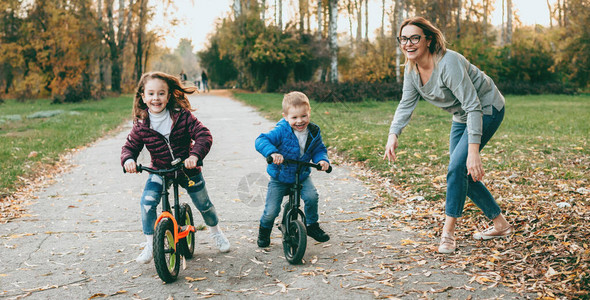她的孩子教他们骑自行车图片