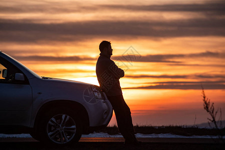 日落时站在汽车旁边的男子汽车旅行概图片