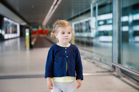 可爱的蹒跚学步的小女孩在机场图片