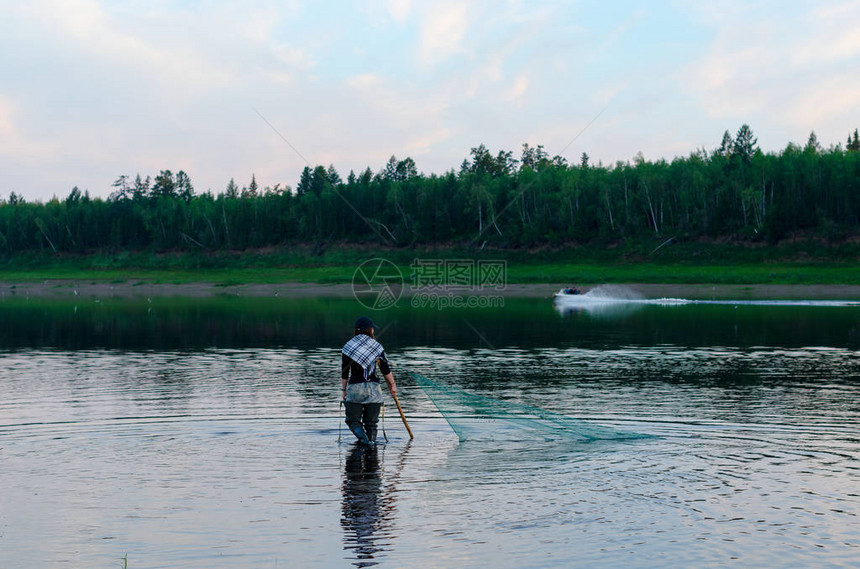 两个男的Yakut和优雅的女孩身穿肖盘在一条船的背面穿过野生北河Vilyui图片