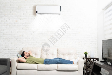 全长的西班牙裔男人睡在家里客厅沙发图片
