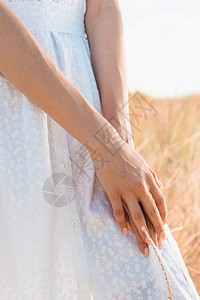 在草原上站着的白色夏裙女图片