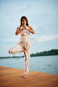 整个白种女人在码头上站着站在半莲瑜伽的图片