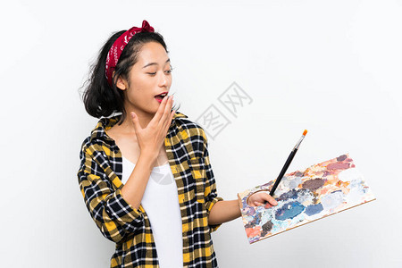 年轻女艺术家在孤立的白色背景上拿着调色盘图片