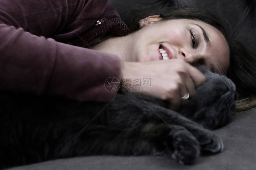 与黑英国猫躺在床上的女人图片