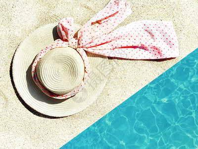 在白沙和蓝海背景上的女暑假帽图片