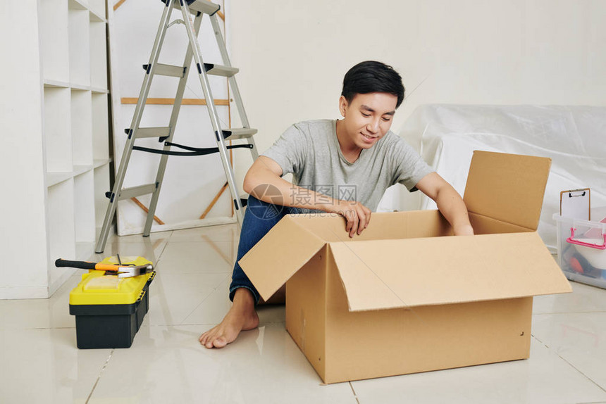 英俊的亚洲年轻男人在新公寓拆卸工具图片