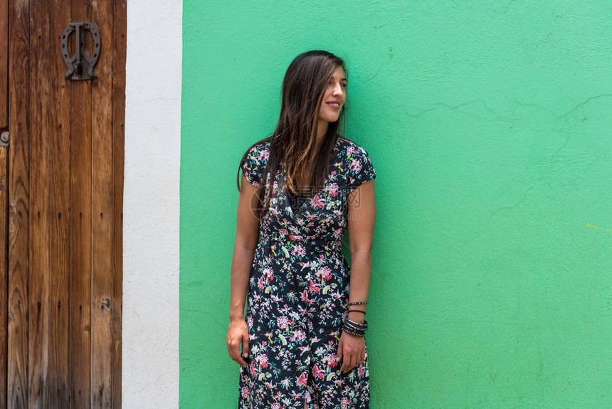 在墨西哥乔鲁拉的美丽绿色外墙前身着裙子的女人图片