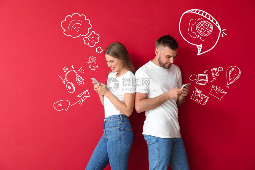 快乐的年轻夫妇与手机在彩色背景图片