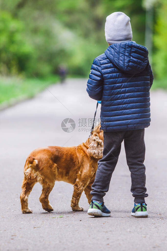 有小棕狗的小孩跑在城市公图片