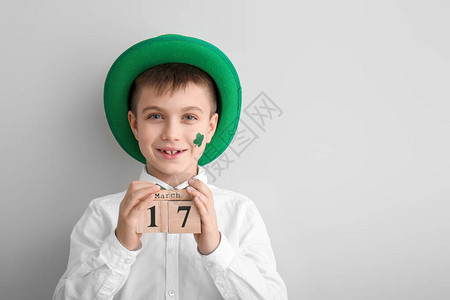 有趣的小男孩与白色背景上的日历圣帕特里图片