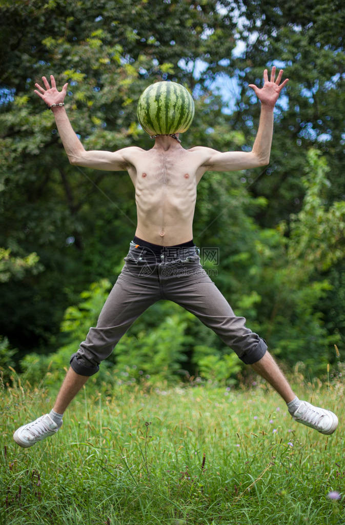 有机食品和健康的生活方式概念一个男孩带着西瓜而不是头在自然背景上的图片