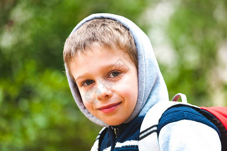 一个背着包的男孩的画像一个孩子在公园里散步微笑的孩子一个图片
