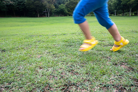 一个孩子的腿在草坪上奔跑图片