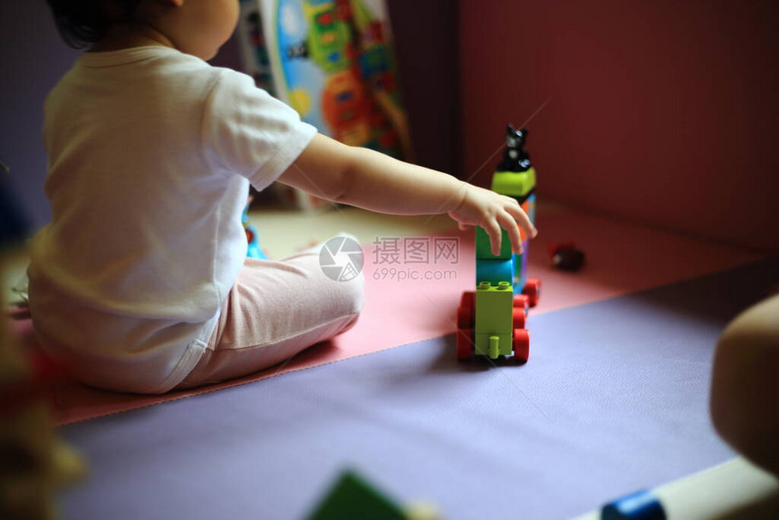 模糊的婴儿在背景中玩具块选择地专注于由彩色木块制成的城堡宝边玩学幼儿阶段的大图片