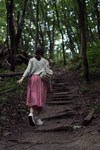 年轻女子走上森林之路图片