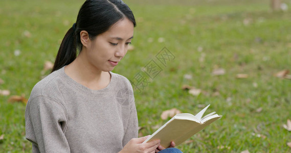 年轻女子在公园读了一本书图片
