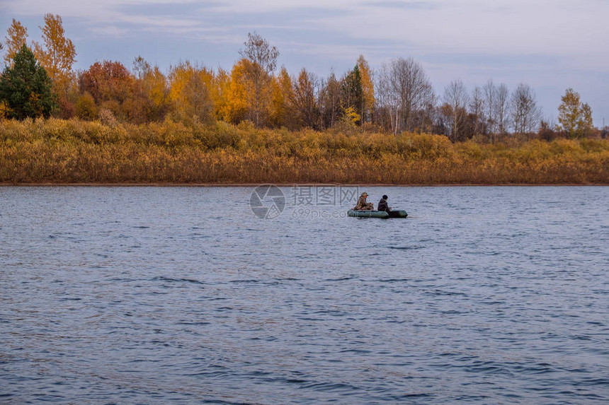 秋天河上橡皮艇上的渔民图片