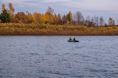 秋天河上橡皮艇上的渔民背景图片