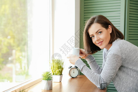 清晨在窗户附近喝咖啡的美图片