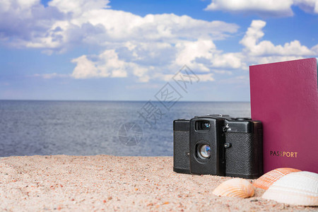 护照古董胶片相机和金沙滩上的贝壳图片