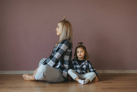 坐在莲花面前的年轻母亲和女儿坐在地板上图片